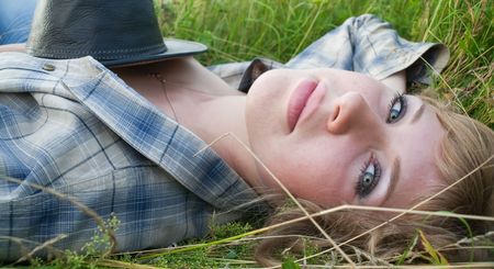 Sexy girl in grass with cowboy hatの写真素材