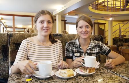Beautiful girls relaxing at coffee-room with a cup of tea の写真素材