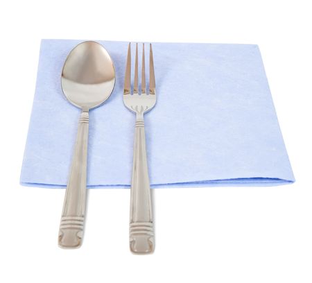 silvery fork and spoon on blue napkin over whiteの写真素材