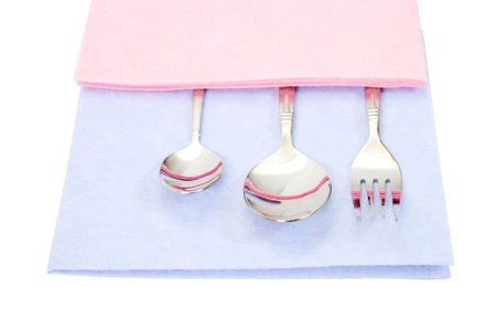 silvery spoons and fork, covered by a nice pink napkin の写真素材
