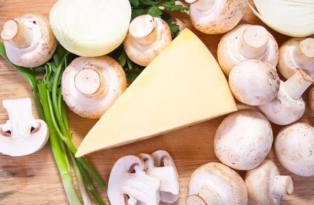 Closeup of champignon mushroom with cheese on cutting board の写真素材