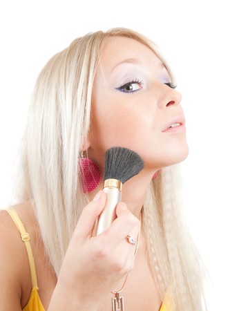 young woman putting make up on her face. Isolatedの写真素材