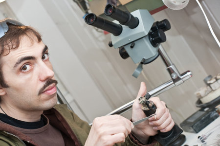 Male jeweller is working at jeweller's workshop