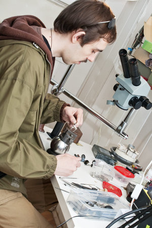 Male jeweller is working at jeweller's workshop