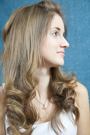 Portrait of long-haired teen girl over blue