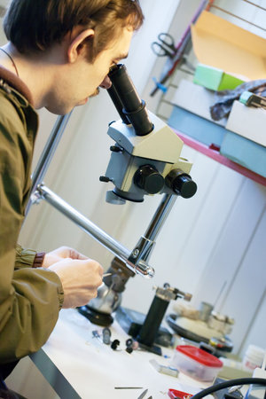 Male jeweller is working at jeweller's workshop