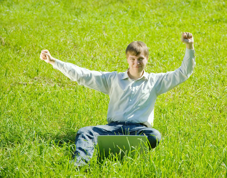 Young smiling men with the notebook outdoorの写真素材