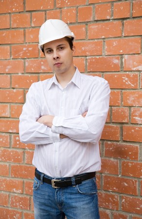 male construction worker in hard hat against  the brick wallの写真素材