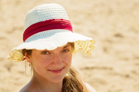 Portrait of teenage girl wearing straw hat on beachの写真素材