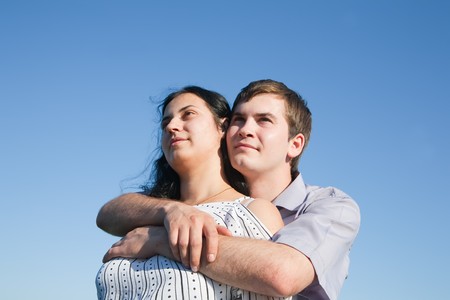 Young couple in love outdoors against blue skyの写真素材