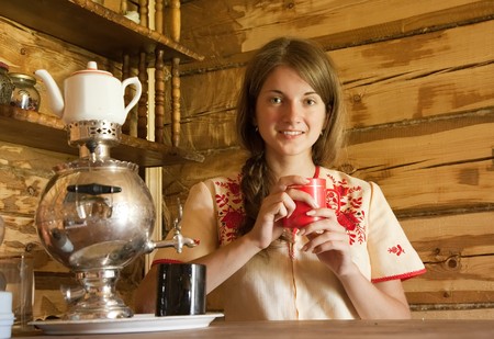 Girl with traditional russian samovar in interior	の写真素材