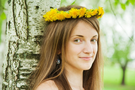 long-haired teen girl in chaplet near birchの写真素材