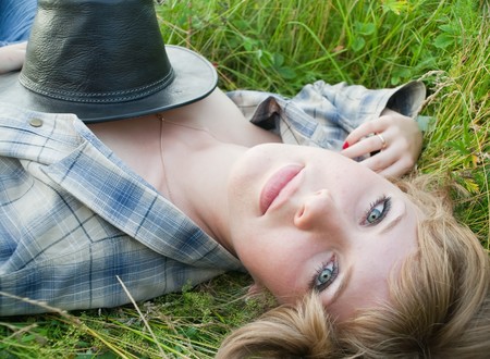 Sexy girl in grass with cowboy hatの写真素材