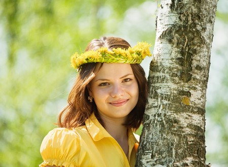 Brunette girl in  dandelion wreath  near birchの写真素材