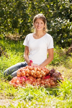 young girl with harvested onion in fieldの写真素材