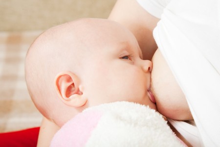 Little baby breast feeding in home interiorの写真素材