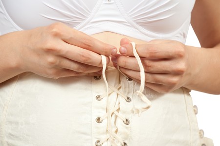  Closeup of pregnant woman dressing body belt. Isolated over whiteの写真素材