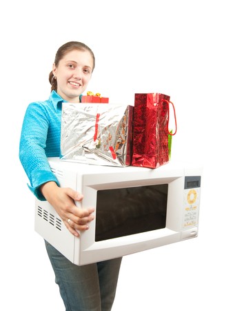 Girl with microwave oven and present boxes. Isolated over whiteの写真素材