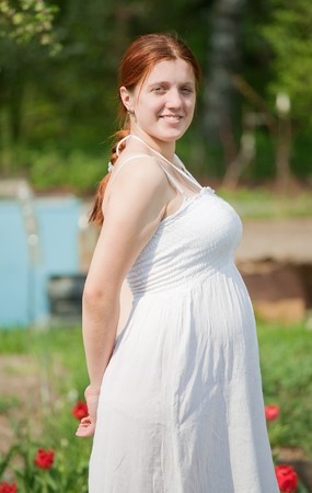 Portrait of 6 months pregnant woman in spring gardenの写真素材
