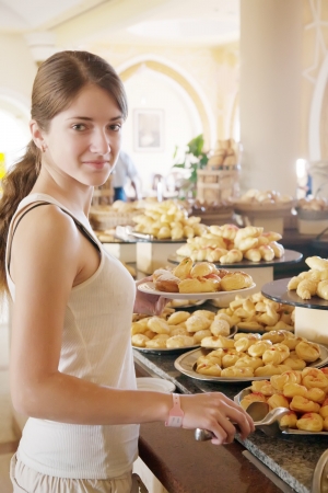 girl chooses sweet meal in buffet at hotelの写真素材