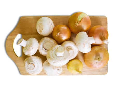 champignon mushrooms with onion on cutting board over whiteの写真素材