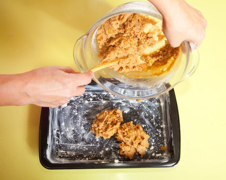  woman puts dough into roasting pan.One of the stages of cooking of  honey cake.  See series