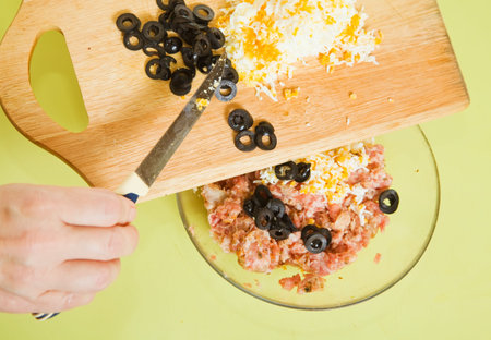  adds grated eggs and  sliced olives in mincemeat.See in series stages of cooking of stuffed tomato...