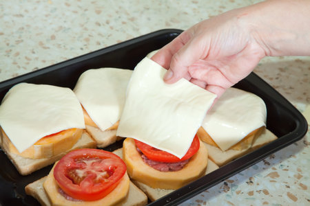 Closeup of cook adds cheese to stuffed vegetable marrow.See in series stages of cooking of stuffed vegetable marrowの写真素材