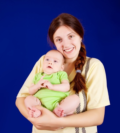 Happy mother with her little daughter over blue backgroundの写真素材