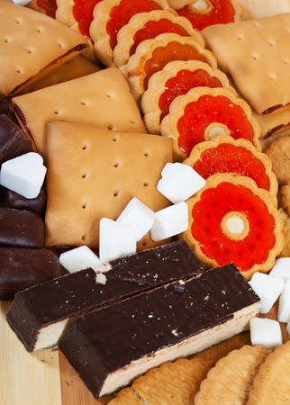 various cookies and  chocolate candy with  sugar on wooden surfaceの写真素材