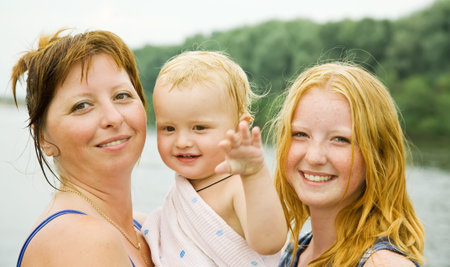 mother with children against river  in summer