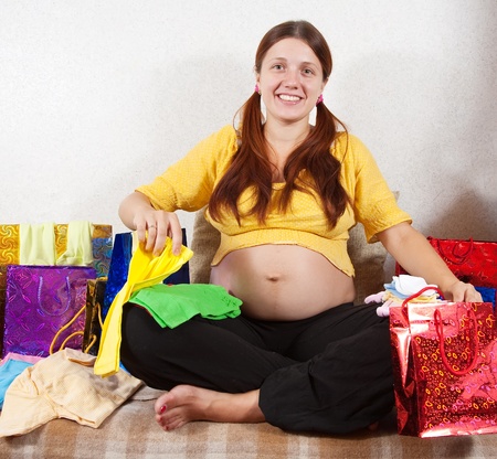 pregnant woman with purchases  on sofa at homeの写真素材