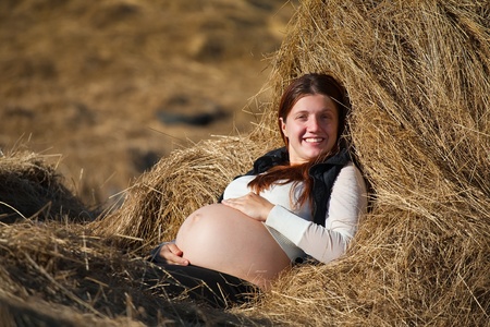 Portrait of 9 months pregnant woman  resting on hayの写真素材