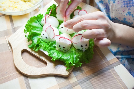 woman is decorating stuffed eggs look like mousesの写真素材