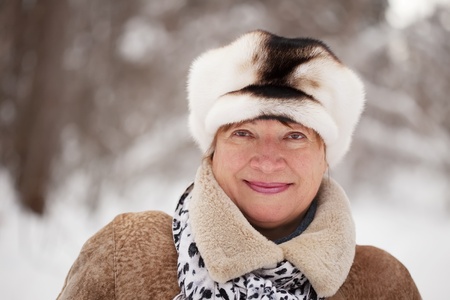 Outdoor wintry portrait of mature woman in winter forestの写真素材