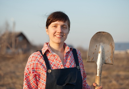 Happy female farmer  with spade  in countryの写真素材