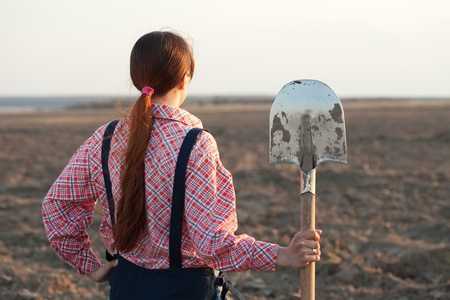 Female farmer  with spade in plowed fieldの写真素材