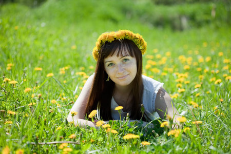 Happy  freckle girl relaxing in dandelion meadow  の写真素材