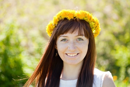 Outdoor portrait of smiling girl in dandelion wreathの写真素材