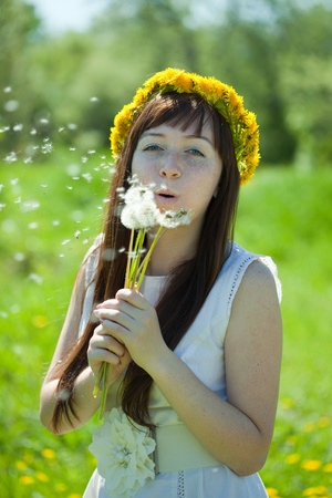 Happy girl blow dandelion  at  meadow の写真素材