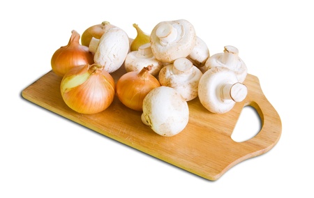 champignon mushrooms with onion on cutting board over whiteの写真素材