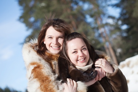 Two happy girls plays in winter parkの写真素材