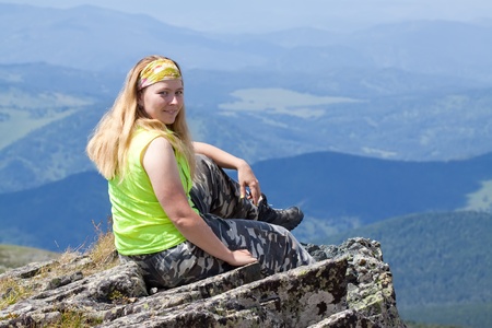 Woman in mountains sitting on mountain peakの写真素材