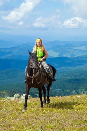 Female rider on horseback at mountainsの写真素材