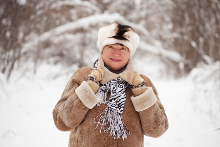 Outdoor wintry portrait of mature woman in winter forestの写真素材