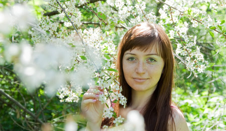 portrait of young woman in the blossoming garden