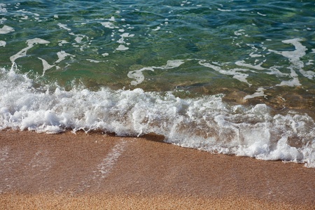 Sea wave breaking against sand beach. Costa Brava, Spainの写真素材