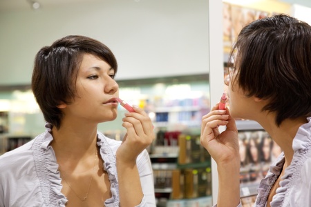 young woman testing the lipstick at cosmetics  shopの写真素材