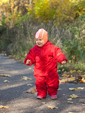 Happy toddler walking  in autumn parkの写真素材