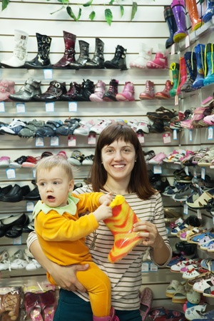 woman with child chooses baby boots  at fashionable shopのeditorial素材
